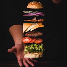 timelapse photo of man holding burger